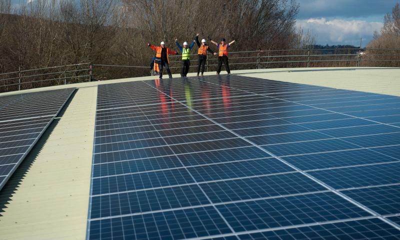 Workers celebrating solar installation on roof of Bristol Indoor Bowls Club