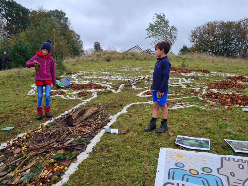 two children standing by outline of Gratitude Tree land art at Planting Day, Tiny Forest Caerphilly