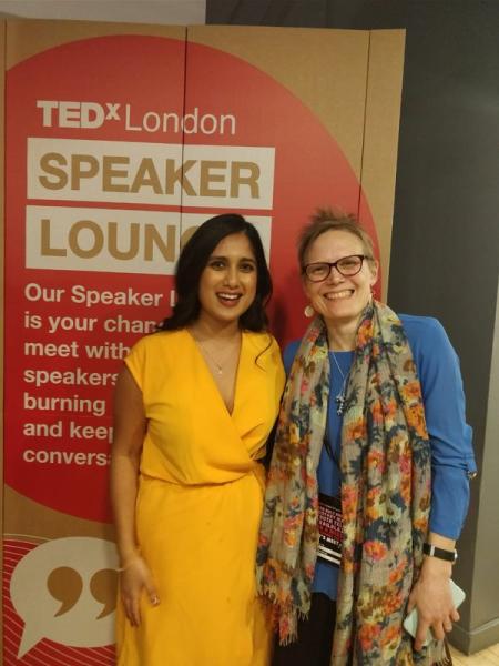 Anneka Deva and Mary Stevens smiling in front of TedX logo on exhibition board