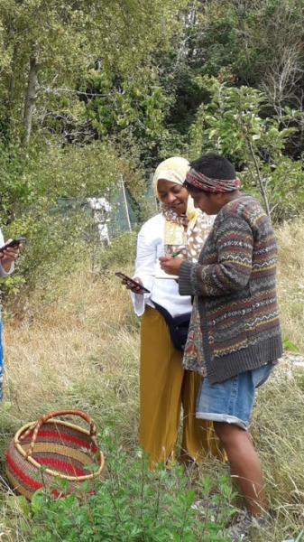 Rasheeqa, herbalist on a nature walk with a woman on Oxford City Farm Refugee Day