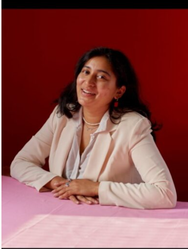 Afreen Saulat sitting at table facing viewer