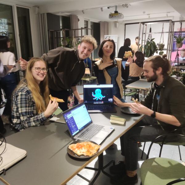 People grouped around a laptop in an office showing the OctopAI logo on screen