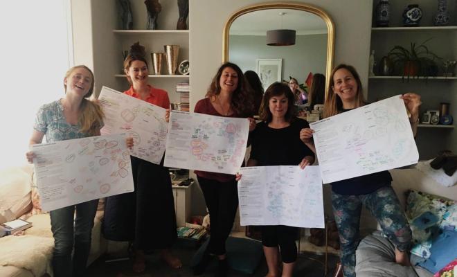 #ownIt group of women working at home together holding flip charts