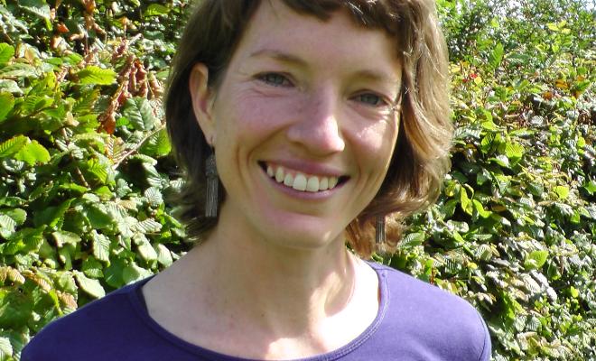 Head and shoulders shot of Harriet Sansom in front of hedge