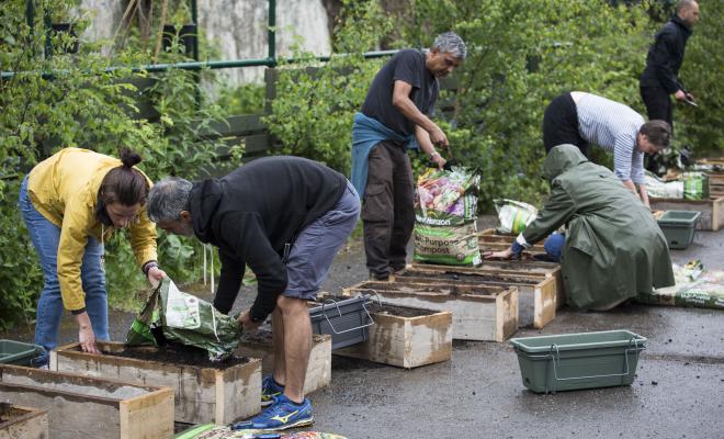 Group of people filling planters with compost