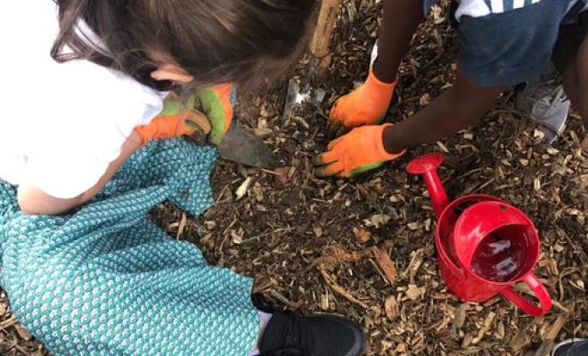 ountford Growing Community - Two children heads together watering a seedling