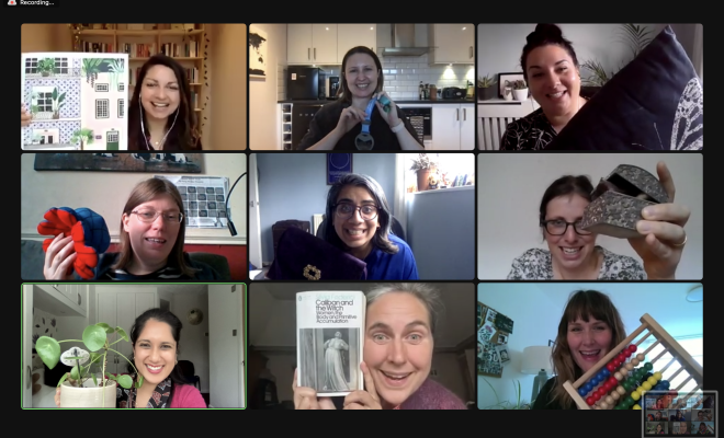 Screen shot of 9 smiling women Money Movers hosts holding up various items to camera during a Money Movers pod meeting online.