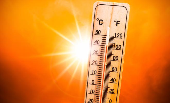 Thermometer with blazing sun in background symbolising heatwave